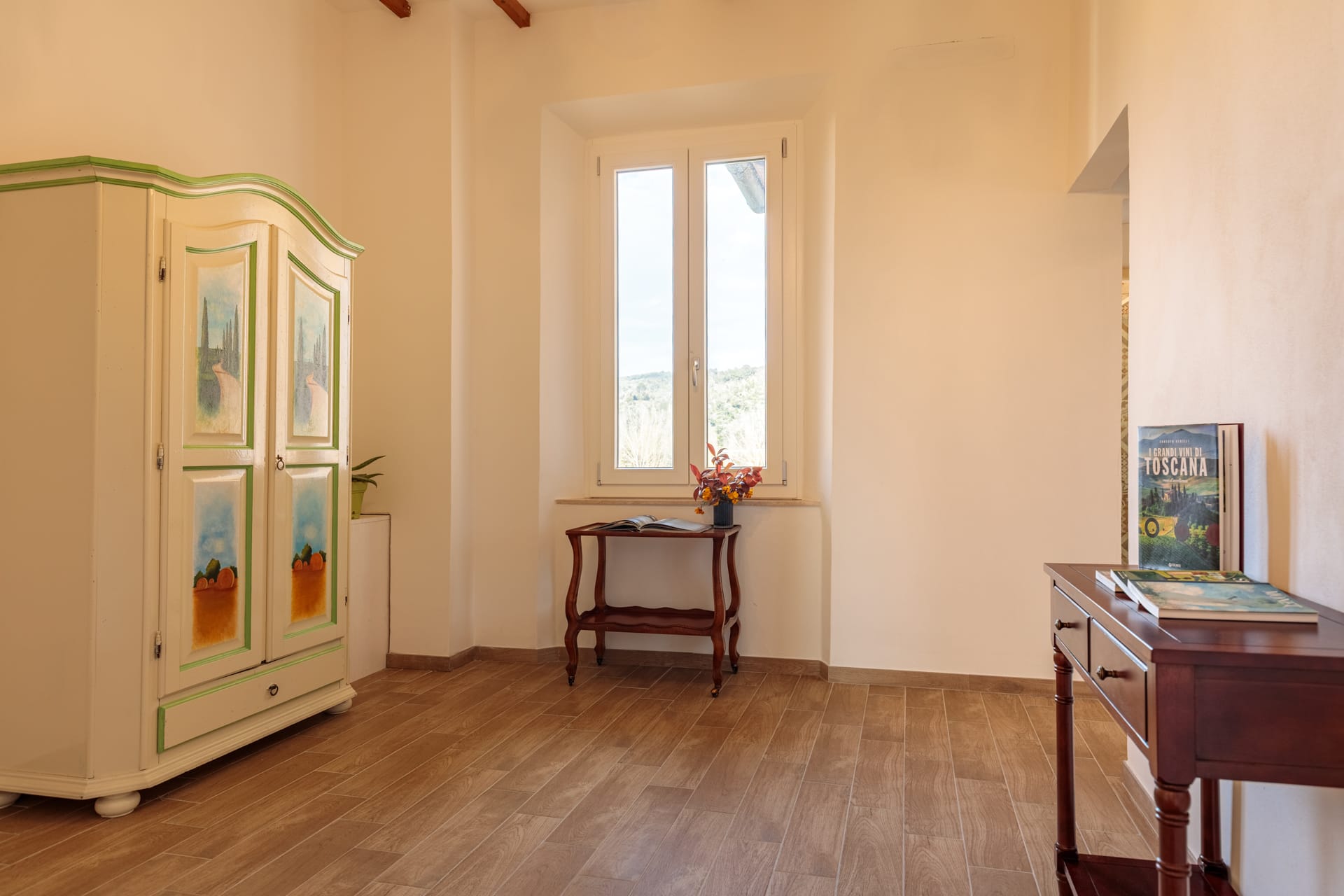 Zona soggiorno della camera di Villa Fontis Rapolano con scrivania, sedie classiche e vista su Rapolano Terme.