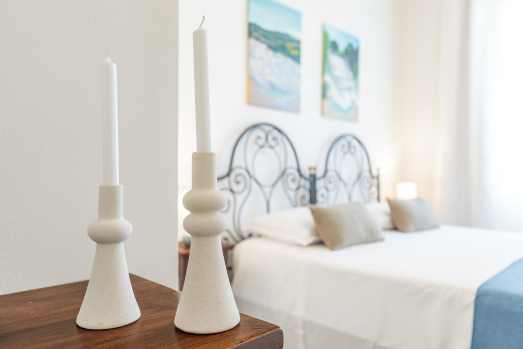 Dettaglio d'arredo della Camera Matrimoniale con Letti Singoli di Villa Fontis con candele decorative e vista sulla camera.