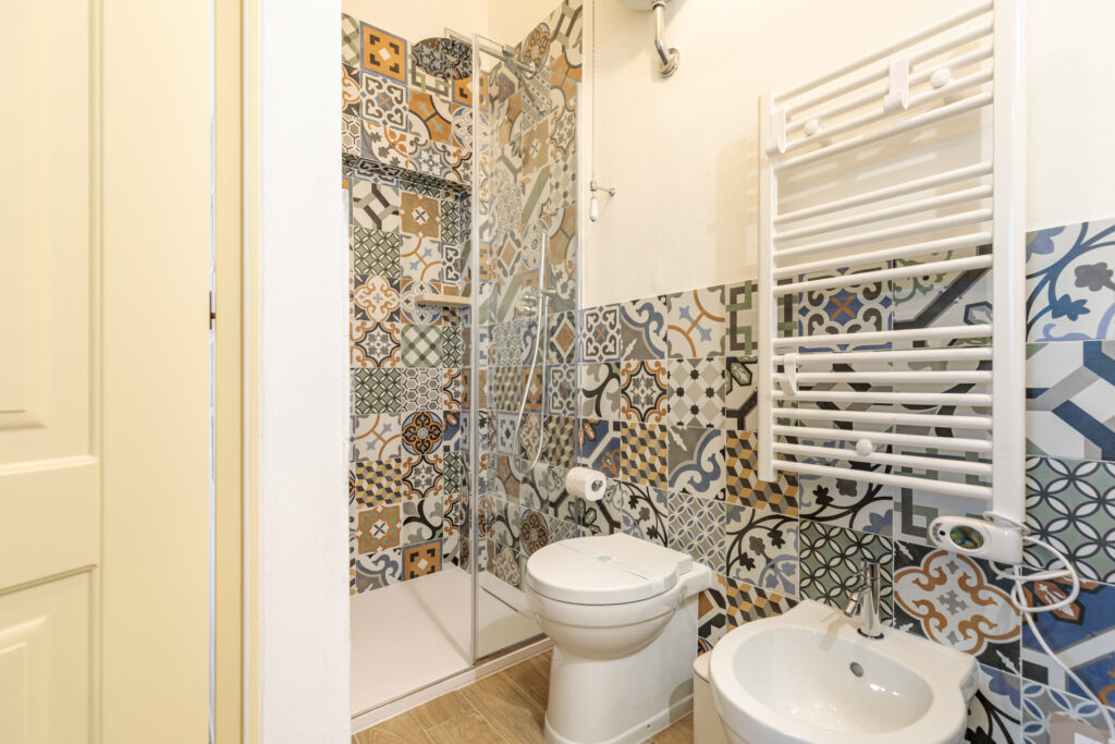 Bagno privato della Camera Matrimoniale Comfort di Villa Fontis a Rapolano Terme con ampia doccia e rivestimenti decorati.