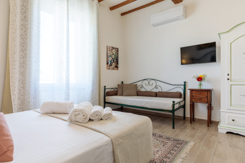 Ampia Camera Matrimoniale di Villa Fontis Rapolano a Rapolano Terme con letto matrimoniale, divano letto, aria condizionata e TV.
