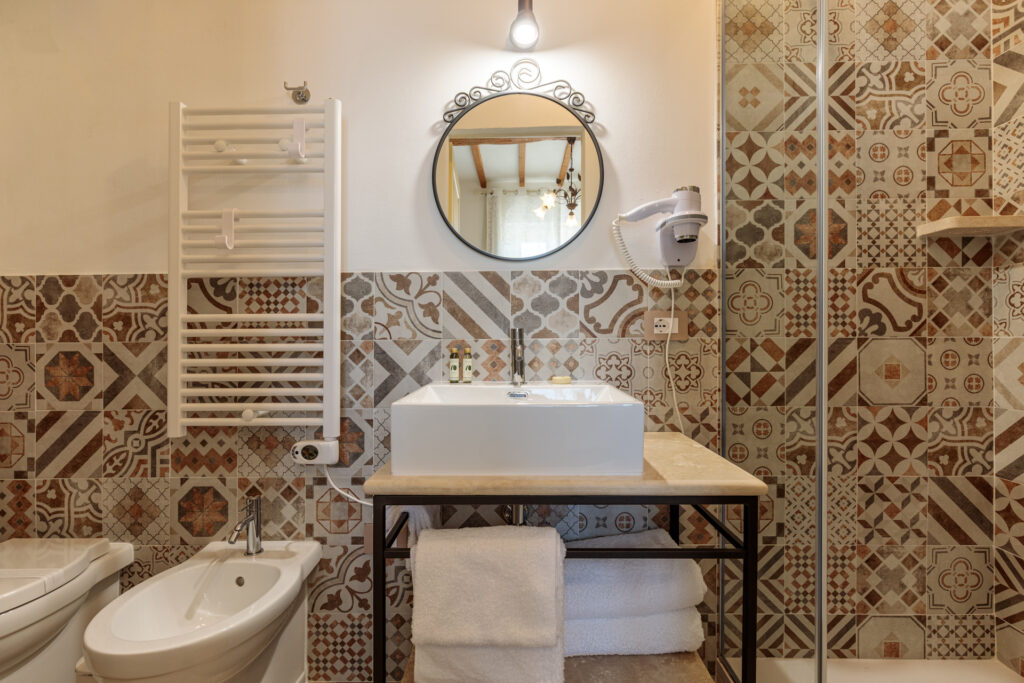 Bagno privato dell'Ampia Camera Matrimoniale di Villa Fontis Rapolano con doccia, lavabo e finiture in stile toscano.