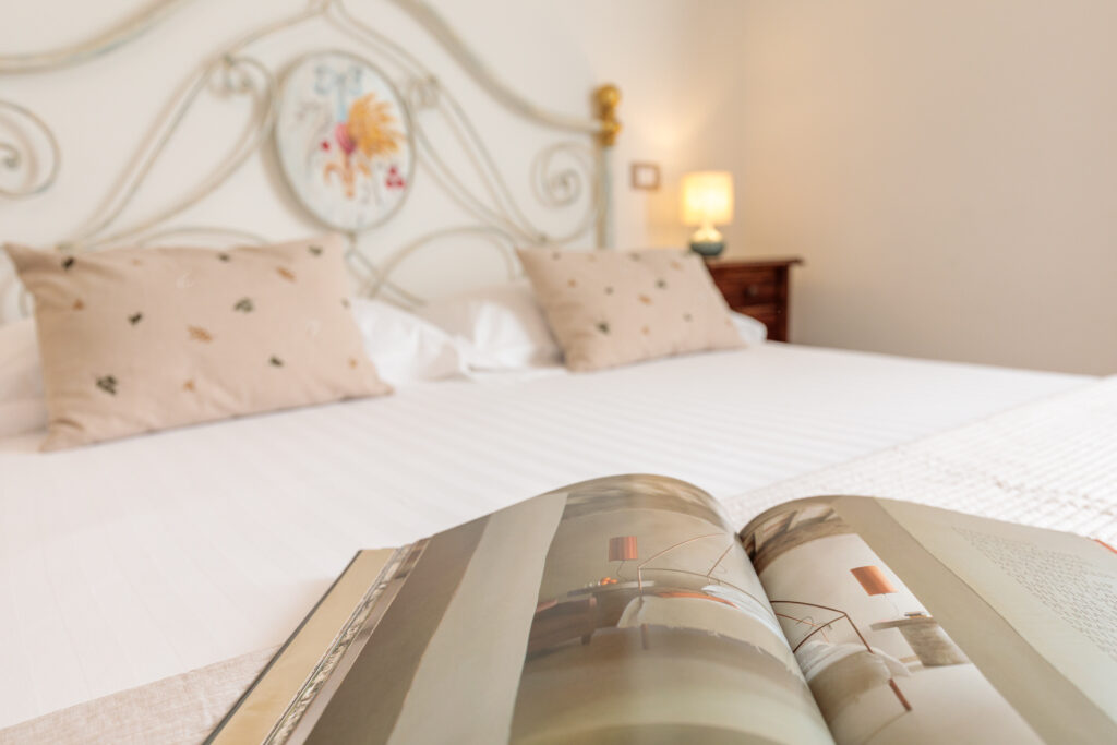 Letto matrimoniale della Camera Matrimoniale Deluxe di Villa Fontis Rapolano con ambiente elegante e luminoso.