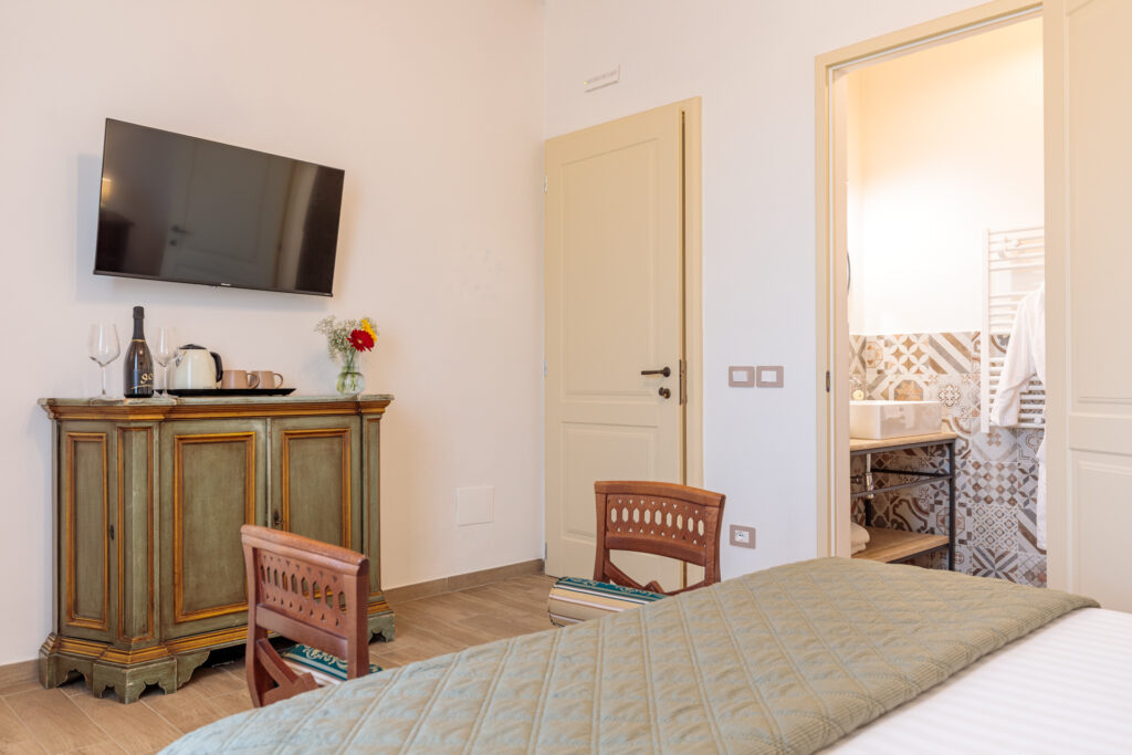 Vista della Camera Matrimoniale Superior di Villa Fontis Rapolano con TV, angolo cortesia, bagno privato e arredi in stile toscano.